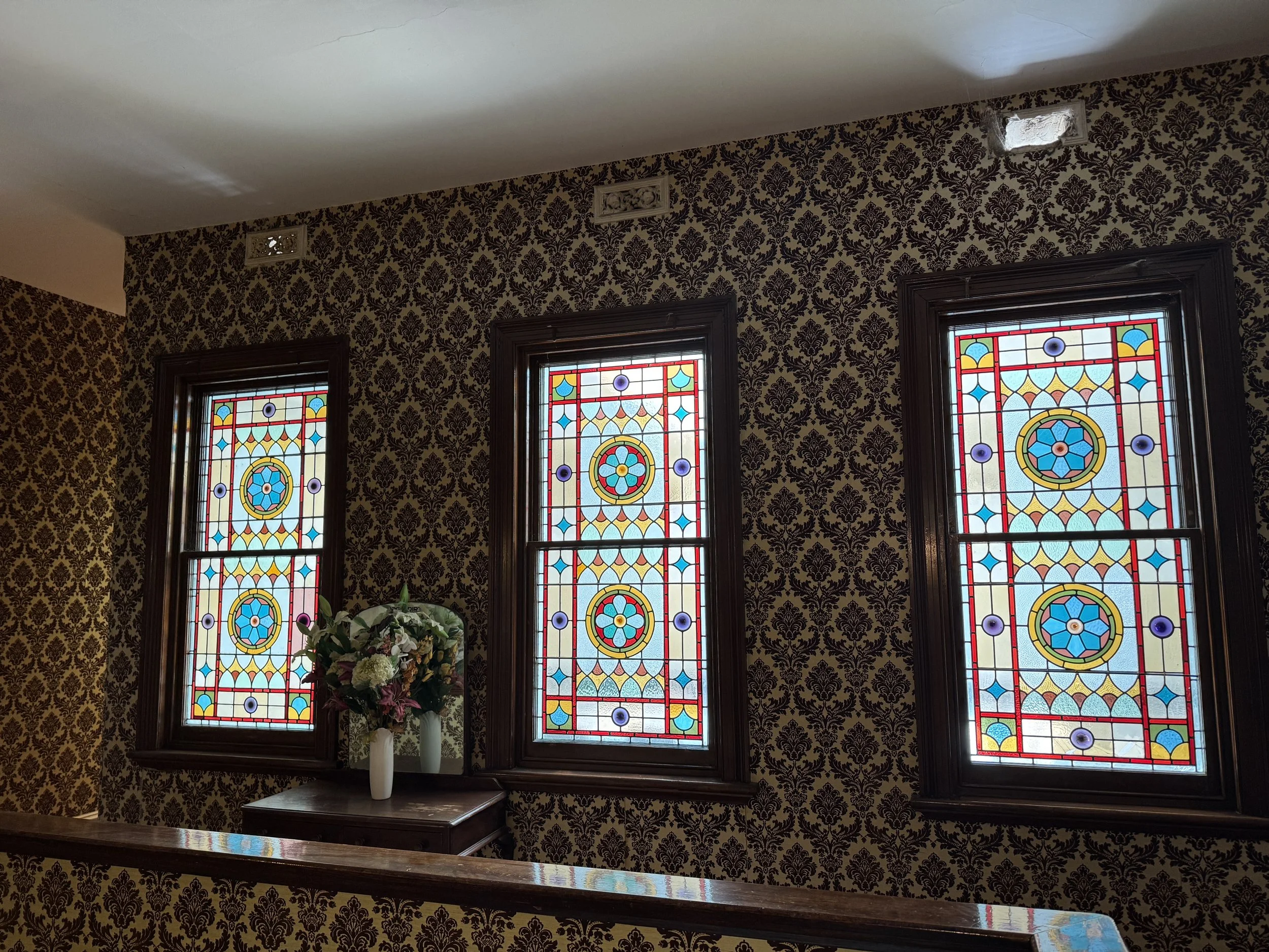 Original stained-glass windows and heritage wallpaper inside the hotel